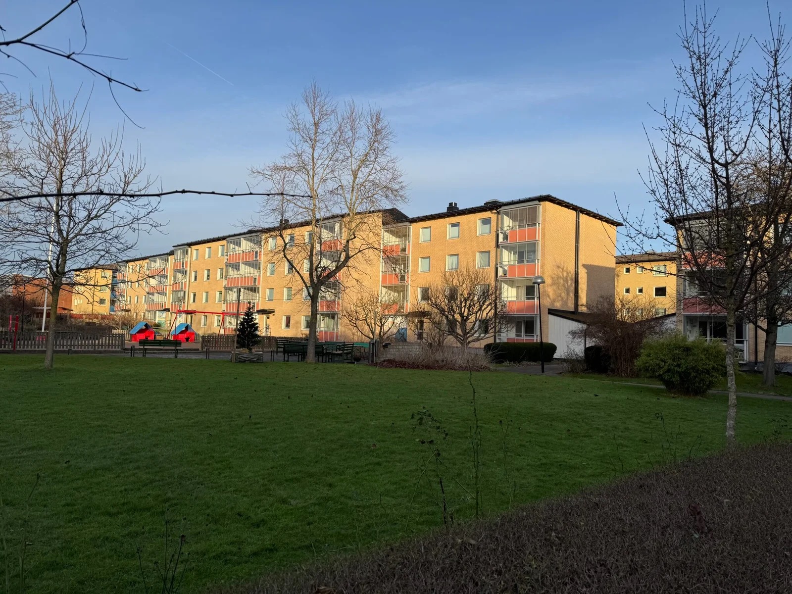 Gula tegelhus i BRF Mölndal, sedda över en gräsmatta