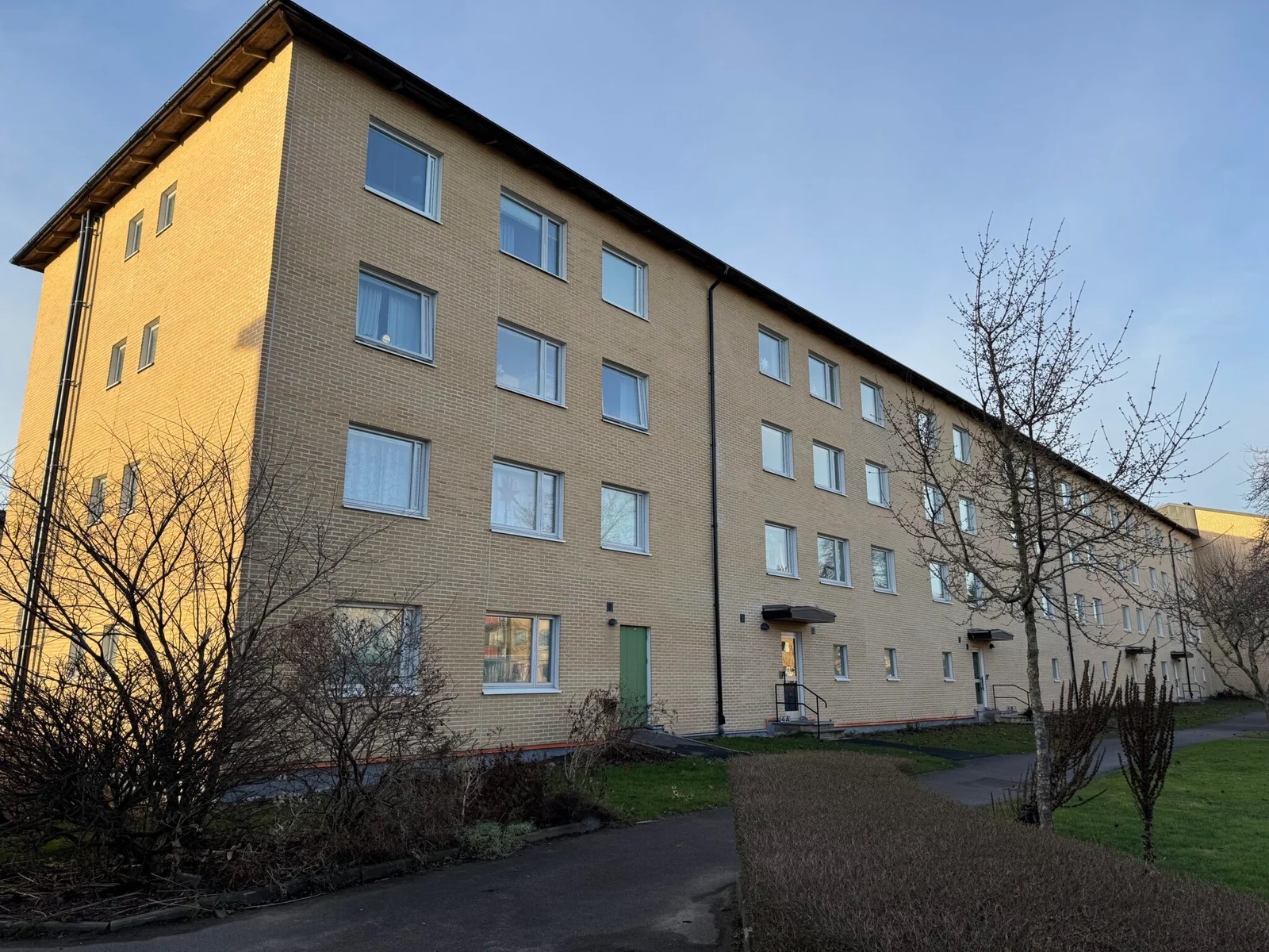Gavel och långsida på ett flerbostadshus i BRF Mölndal, med fasad i gult tunntegel