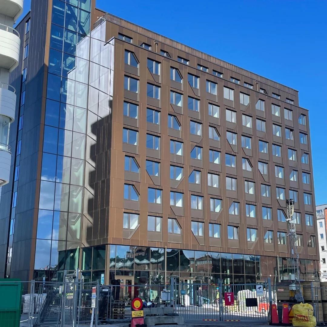 Basecamp Malmö, kopparbrun skivfasad med glasat hörnparti och glasad bottenvåning