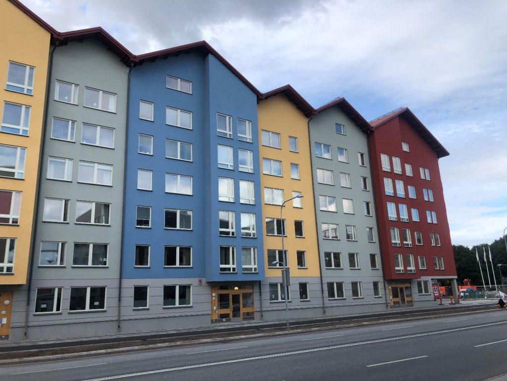 Före och efter bilder av en husfasad i Stockholm, där fasadputs har förvandlat den från sliten till elegant.